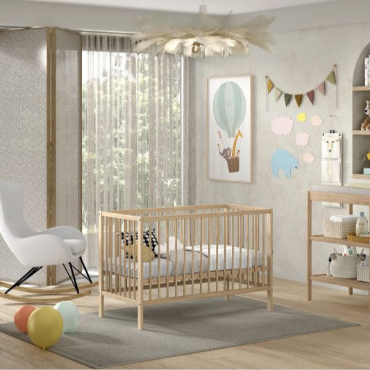 Jolie chambre avec un lit bébé et une table à langer en bois massif et de couleur Bois naturel