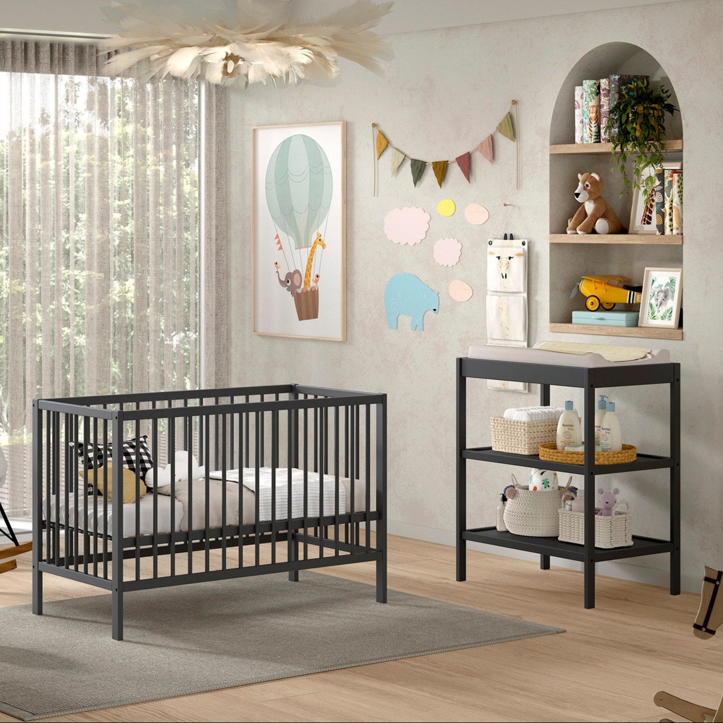 Jolie chambre avec un lit bébé et une table à langer en bois massif et de couleur anthracite