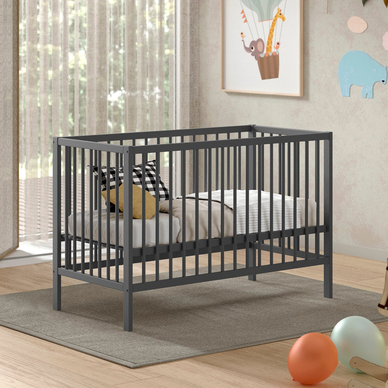 Jolie chambre avec un lit bébé en bois massif et de couleur anthracite