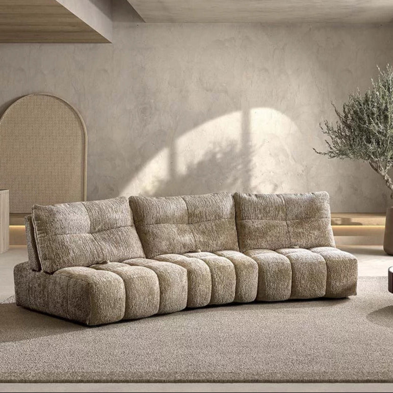 Beau canapé Heidi beige sable, avec des formes rondes, 3 dossiers qui se reculent, sans accoudoir. Il parait très confortable et douillet 